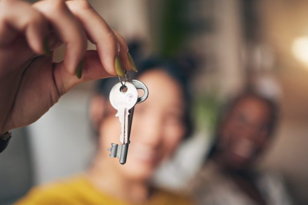 Keys, hand and new home or people moving in together for real estate investment. Rent, mortgage and.